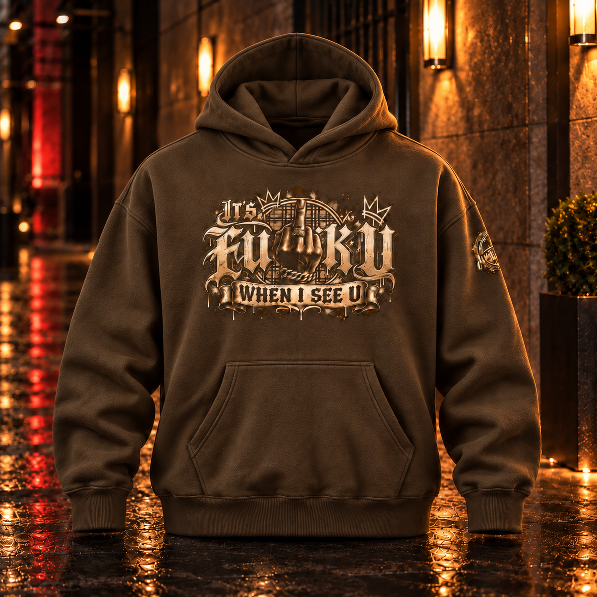 Front view of the Coffee Anyweather FUCK U WHEN I SEE U oversized fleece hoodie in a wet nighttime corridor